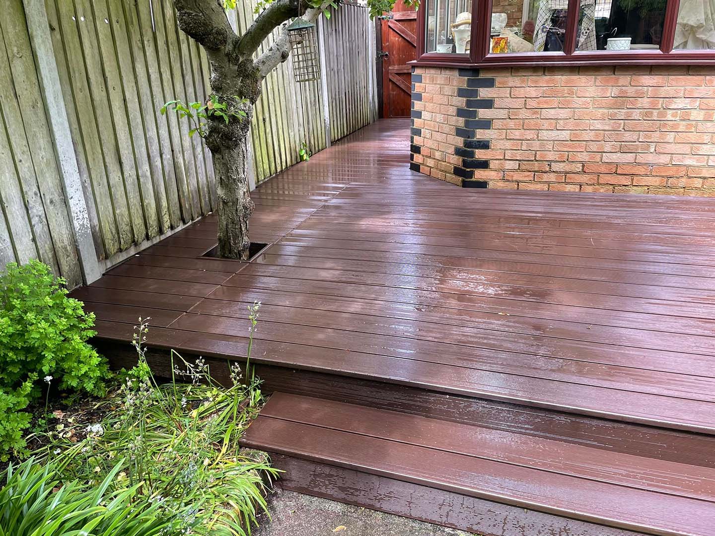 Wooden decking around the side of a house