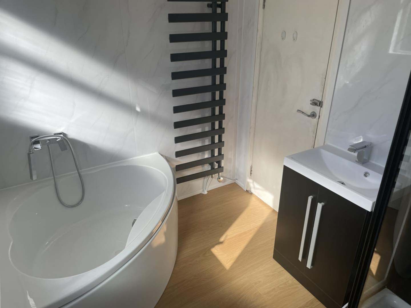 Corner bath with tall black radiator